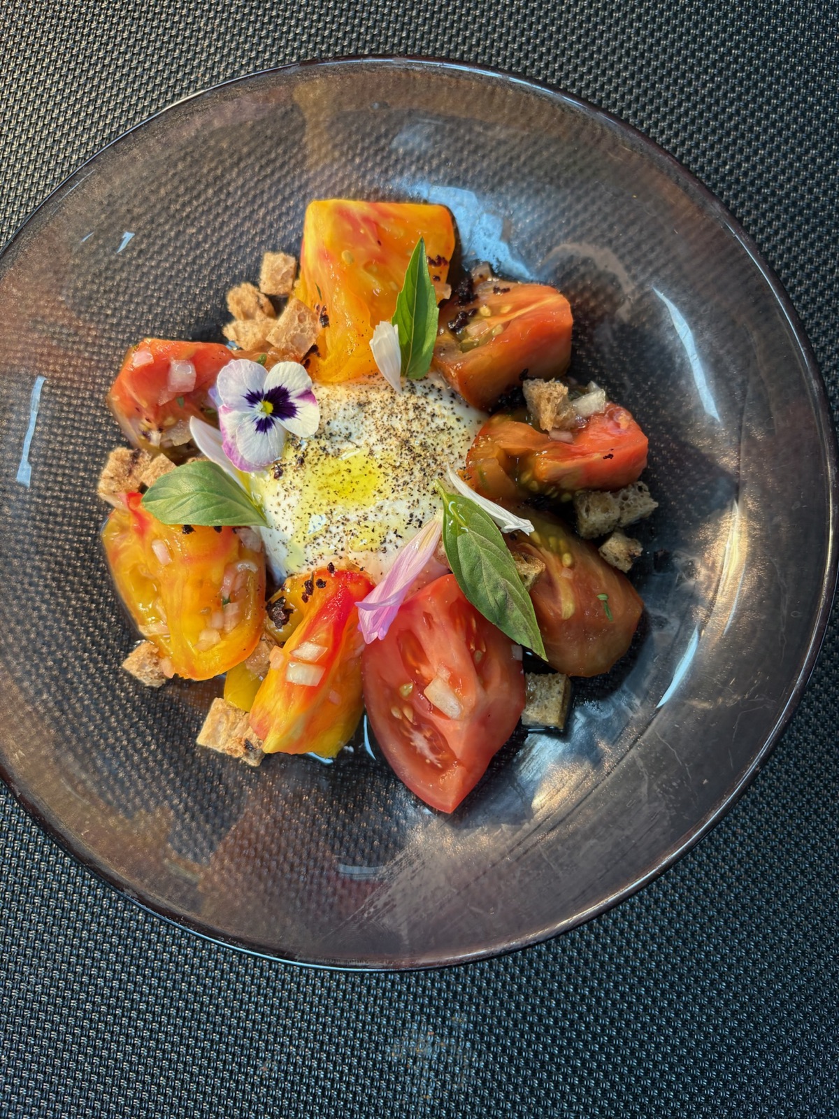 Heirloom tomatoes with a soft egg, basil and blossoms
