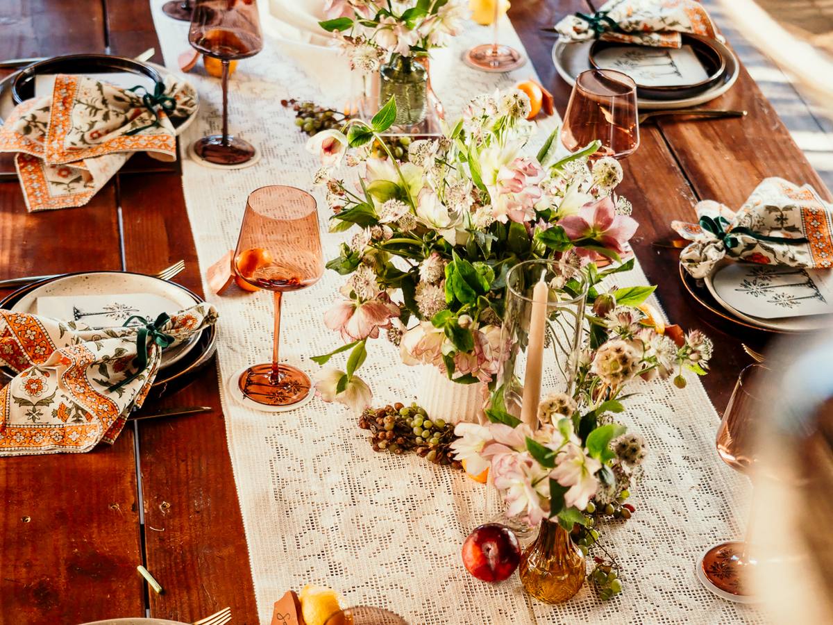 An outdoor reception table set with flowers and candles